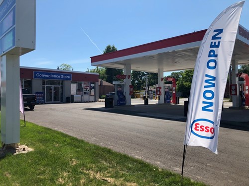 McDougall Energy Team Helps Open New Esso Location in the GTA 131 Shows exterior shot of Esso gas station with a large stake banner with words Esso Now Open