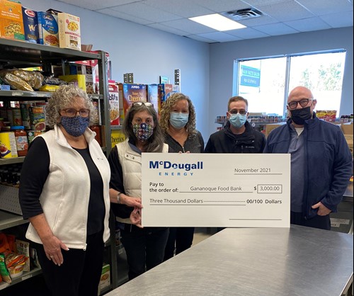 McDougall Energy donates $9,000 to Kingston Community Organizations 63 Shot of 5 people standing indoors at a food bank wearing face masks holding a large cheque from McDougall Energy
