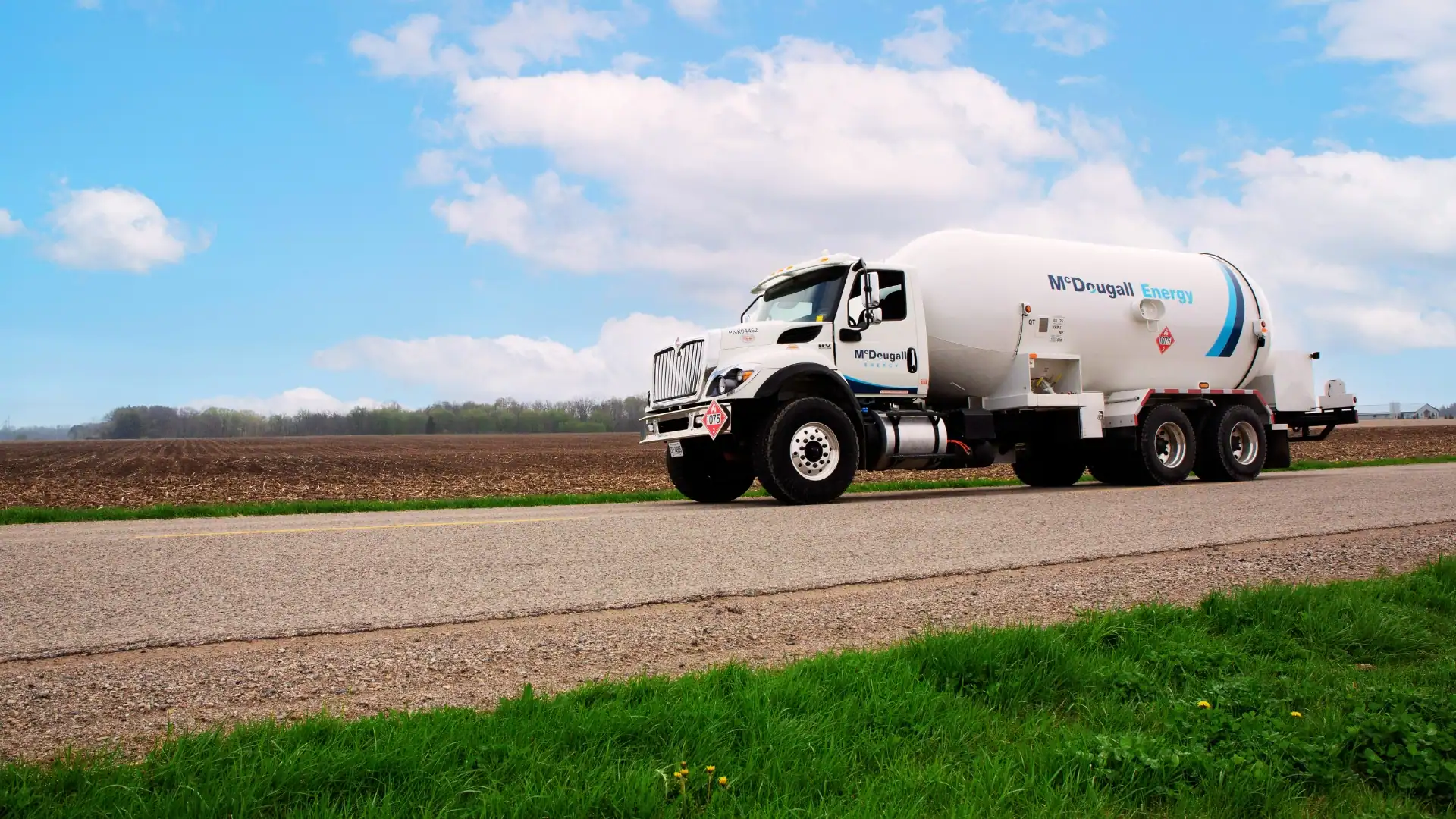 Refueling tanker truck on rural road for fuel delivery and transportation services.