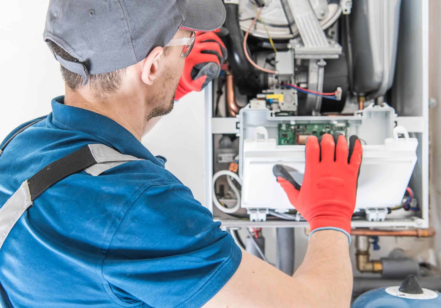 High-efficiency HVAC technician repairing heating system, as part of the annual HVAC service plan from McDougall Energy.