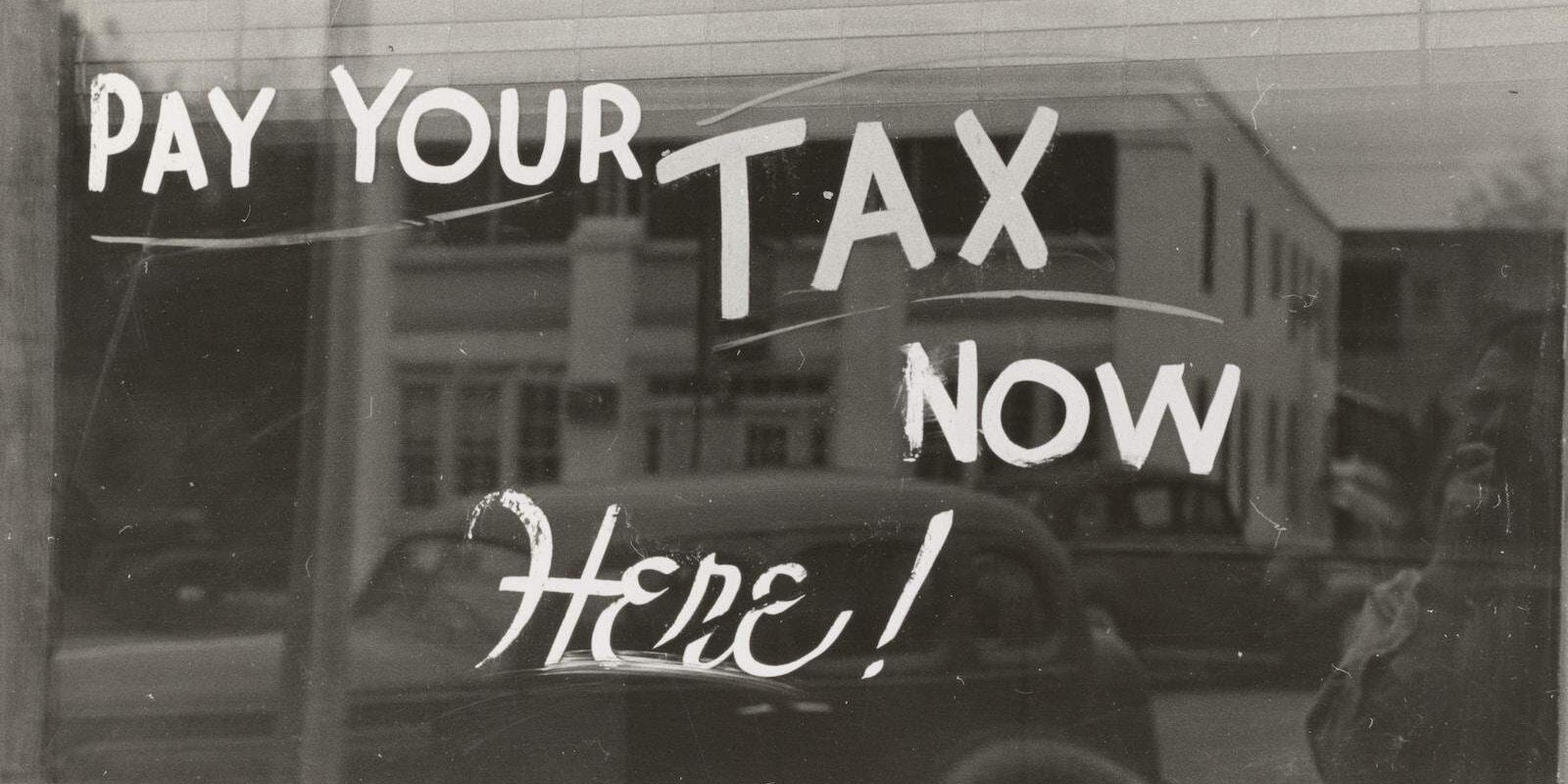 a sign that says pay your tax now here
