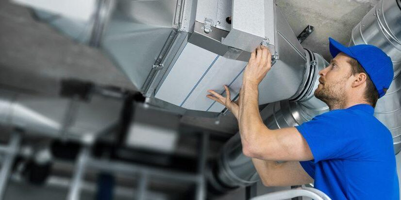 HVAC worker servicing duct work